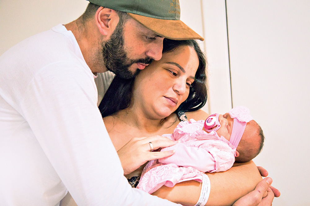 Imagem mostra o casal Renato Celestino e esposa Lilian com a filha recém-nascida Lívia