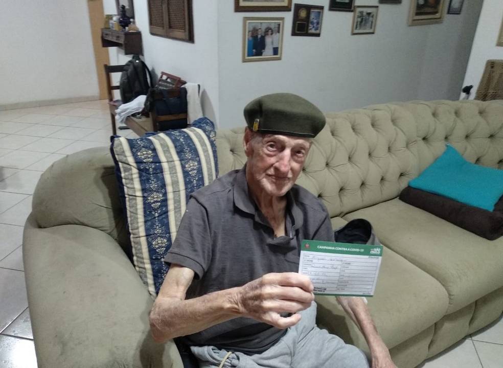 Miguel Garofalo, de 99 anos, exibe carteira de vacinação.