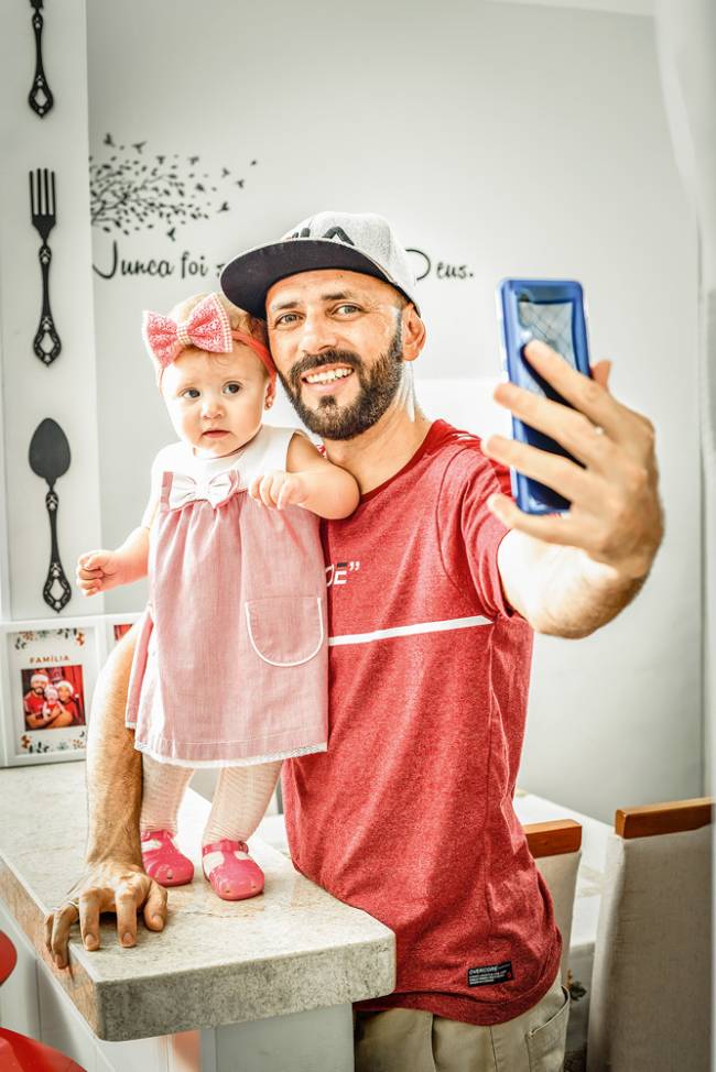 Imagem mostra o casal Renato Celestino e filha Lívia posando para foto encenando uma selfie