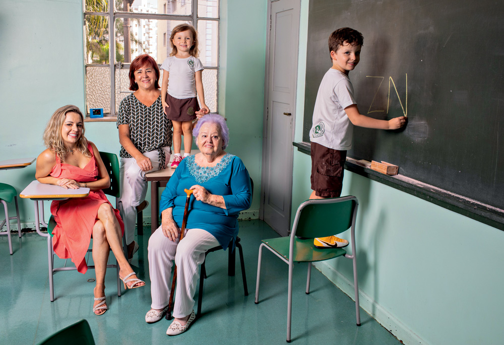 SANTANERS Família em uma sala de aula, com um menino rabiscando a lousa