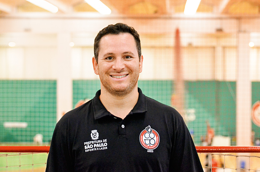 Tiago, com uma camisa da prefeitura, sorrindo para a foto