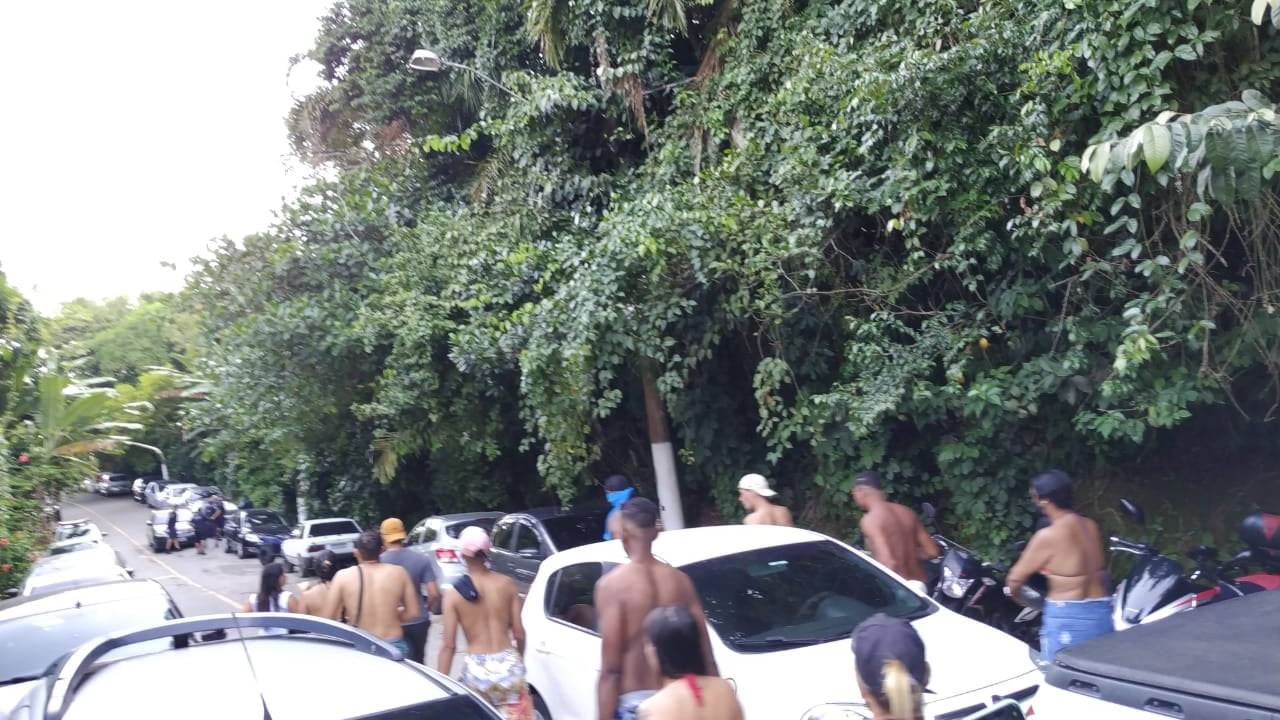Imagem mostra jovens em rua cheia de carros, saindo de praia no Guarujá