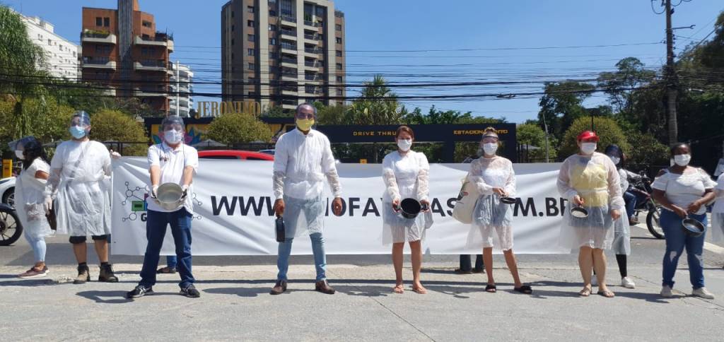 panelas-vazias-destaque manifestantes posando para a faixa segurando um cartaz