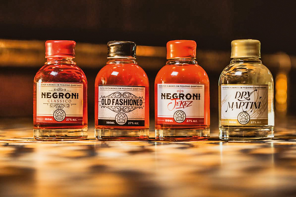 Quatro coquetéis engarrafados, um seguido do outro, da marca APTK Spirits