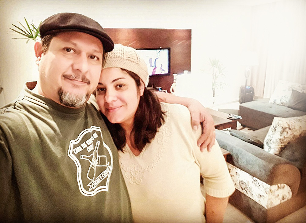 Eduardo e Rosangela Eduardo tira a própria foto do casal. Ele está abraçado com Rosangela, usando uma boina, e ambos sorriem para o celular.