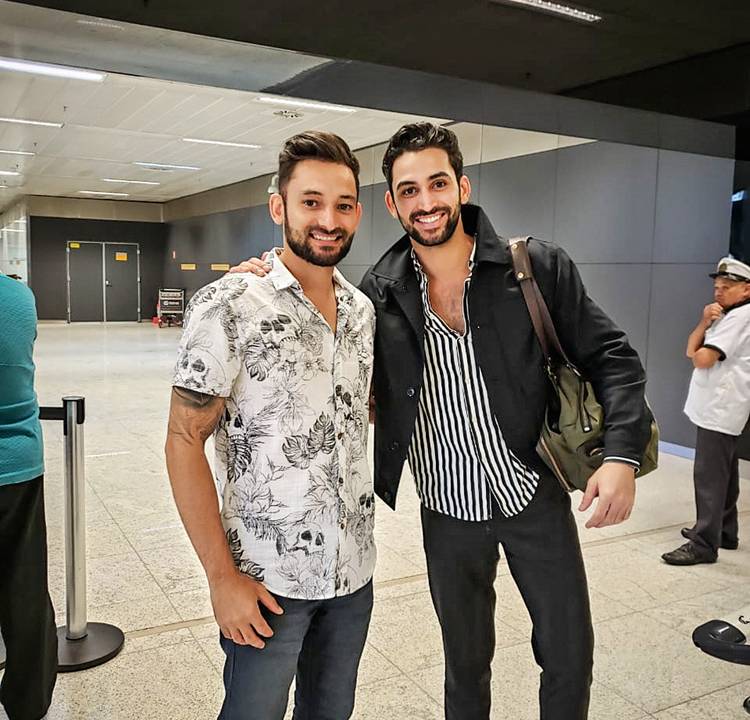 Os irmãos paulistas Erick e Kelvin abraçados posando para a foto em aeroporto.