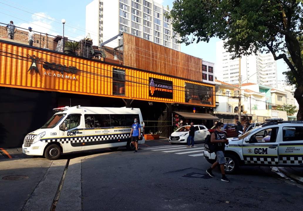 Imagem mostra a fachada da academia com viatura da polícia estacionada