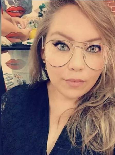 Imagem é uma selfie de Andressa. A moça tem cabelos longos loiros, olhos azuis e usa óculos