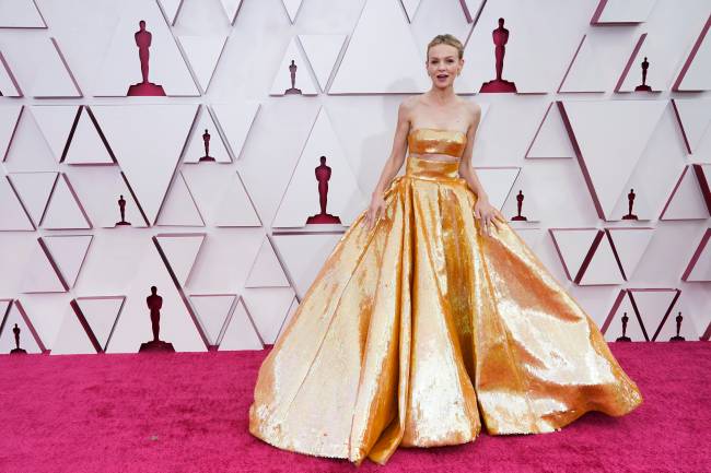 carey A atriz Carey Mulligan no tapete vermelho do Oscar com um vestido dourado