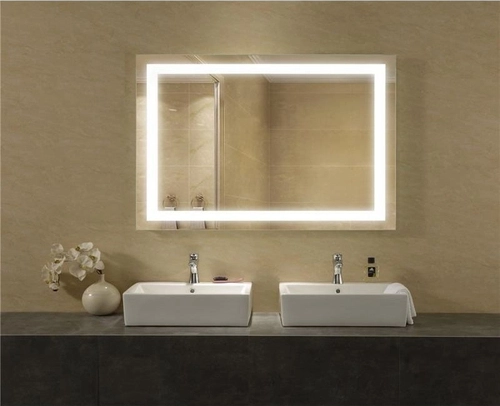 Banheiro em frente a um espelho retangular com luz de led com duas pias embaixo