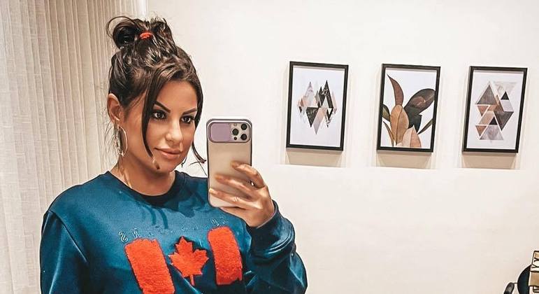 A imagem mostra Livvia Bicalho com o celular na mão fazendo uma selfie