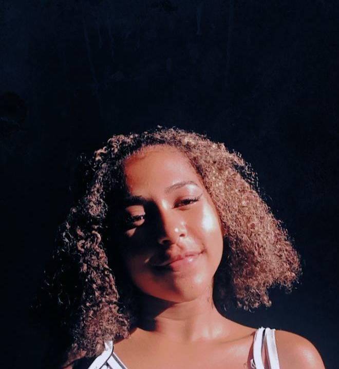 A imagem mostra um retrato de Aguida, com o sol chegando só em metade de seu rosto, vindo da direita para esquerda