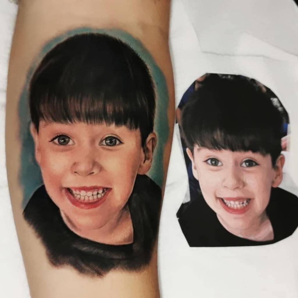 WhatsApp Image 2021-05-07 at 14.45.05 Um braço com uma tatuagem de uma criança sorrindo, ao lado uma foto recortada desta tatuagem