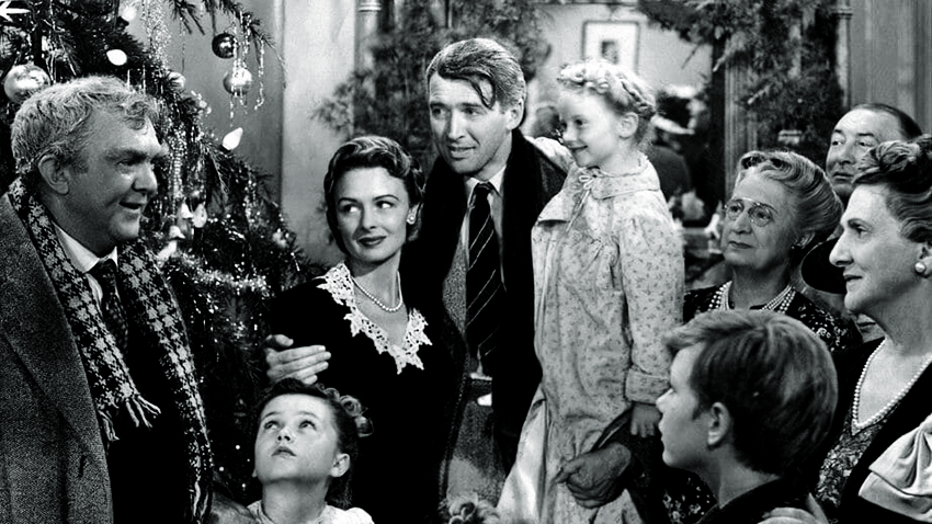 A imagem mostra a fam&iacute;lia protagonista do filme unida em sua sala, com homem abra&ccedil;ado de sua mulher e sua filha no colo.