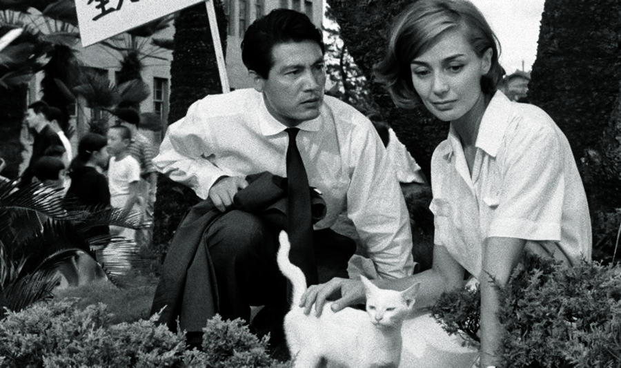 A imagem mostra o casal do filme lado a lado. A mulher est&aacute; acariciando um gato enquanto o homem olha para ela com express&atilde;o de preocupa&ccedil;&atilde;o