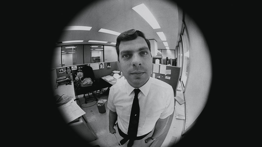 filhosdesam-fotomenor.png A imagem, preta e branca, é um retrato do jornalista Terry mas com efeito 'olho de peixe', em que tudo que fica mais afastado do centro acaba ficando esticado.