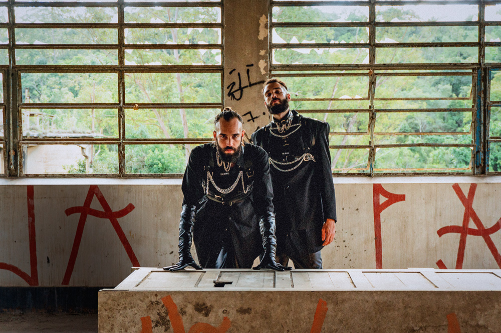 gêmeos 2DE1 posando para clipe gravado em sala pixada