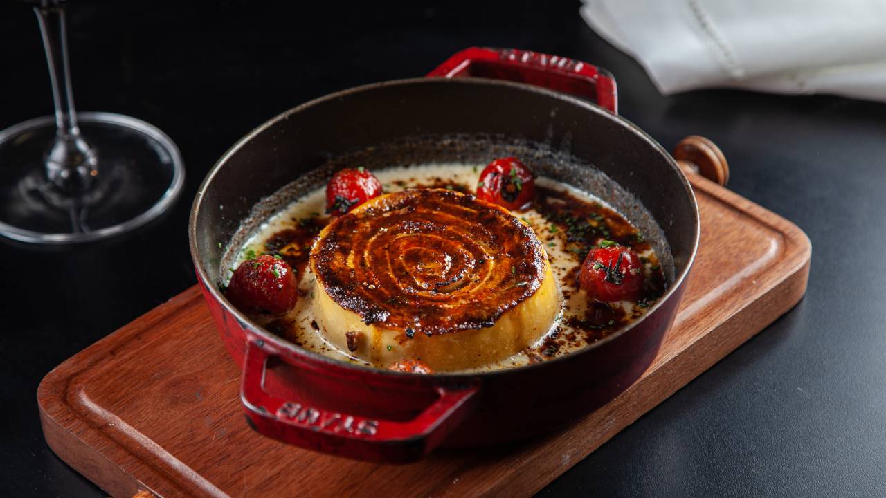 Rotolone em panelinha de ferro, sobre tábua de madeira.