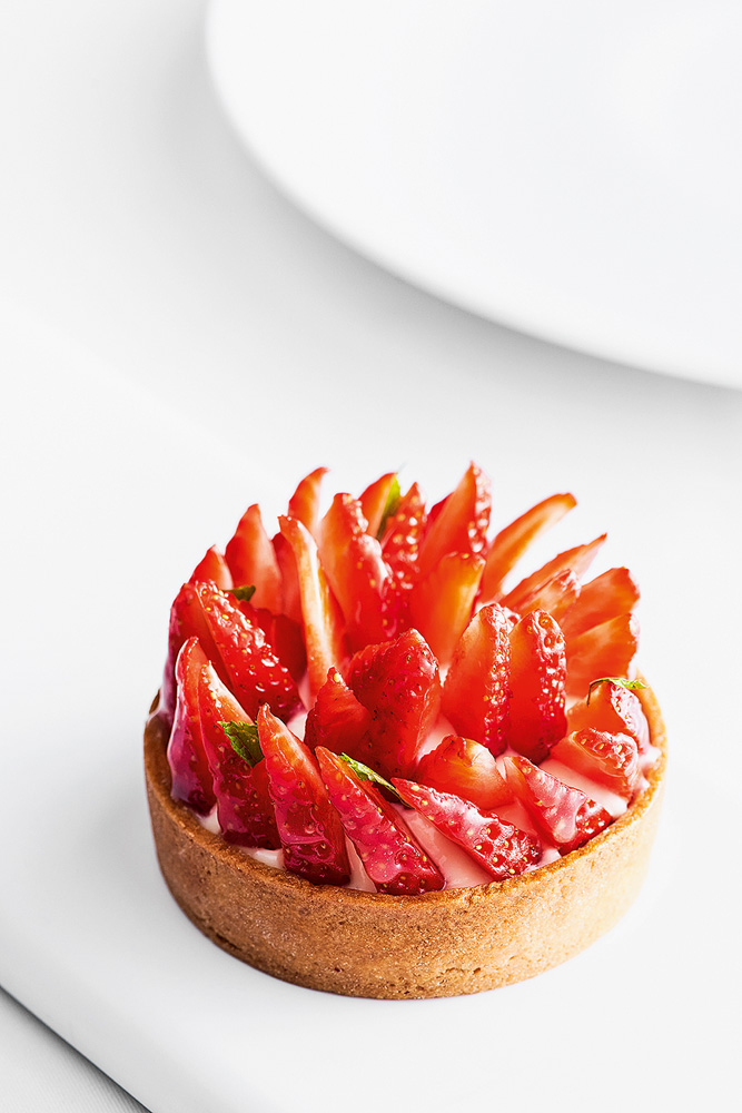 Chef Rouge – Tortinha de morango Torta pequena de morango no centro da imagem com um fundo branco.