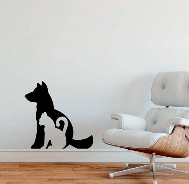 Uma parede tem um adesivo com a silhueta de cachorro e de um gato