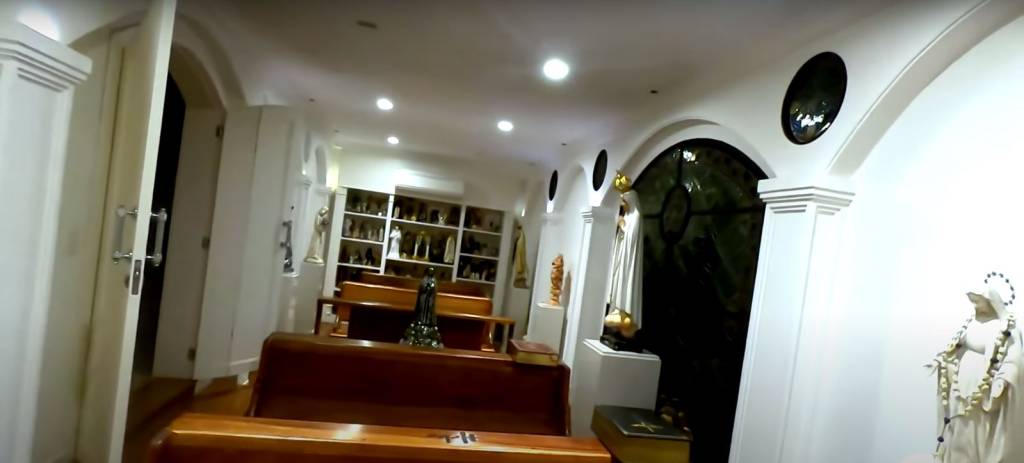 casa-hebe-camargo-capela bancos da capela e, ao fundo, diversas estátuas sacras