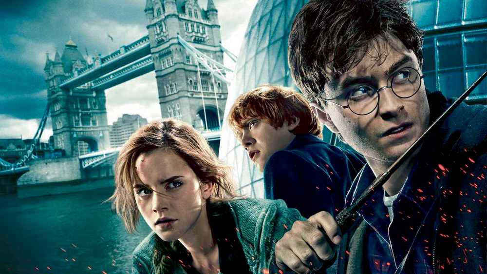 hbomax2-divulgacao.jpg A imagem mostra os três protagonistas do filme Harry Potter com um castelo ao fundo, da ambientação do filme. Eles estão com uma expressão de seriedade.