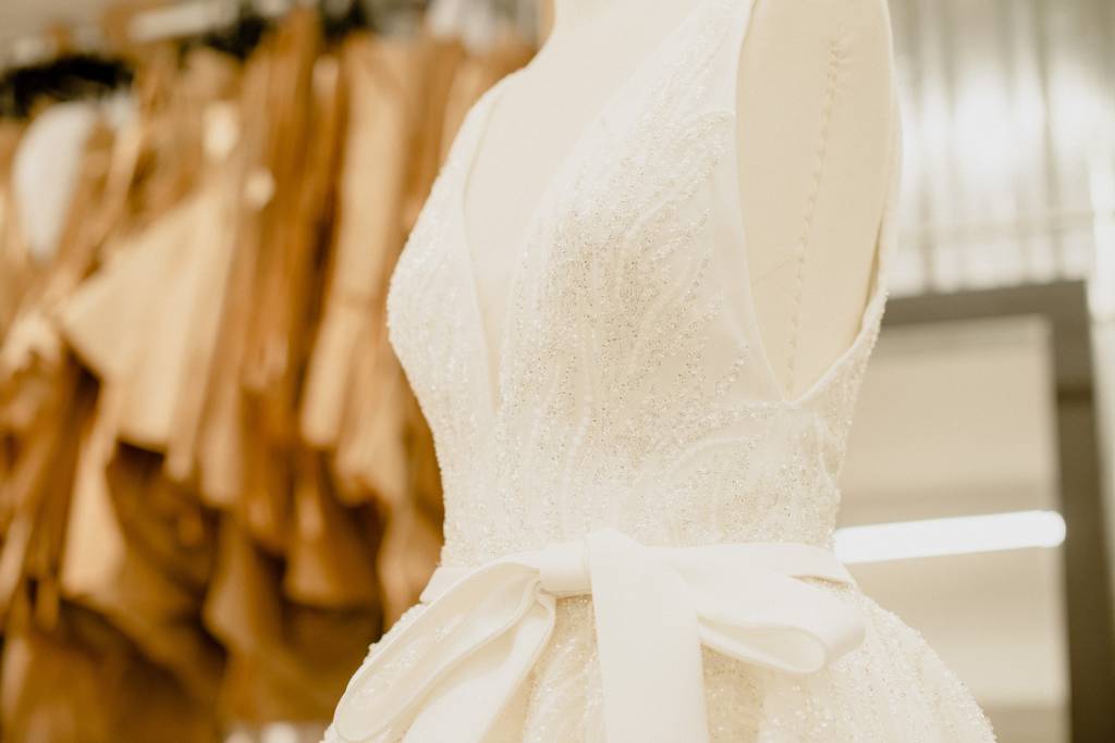 Lucas Anderi – Disney Princess Wedding Collection (Jeff Porto) (2) Imagem exibe parte de vestido de noiva branco com laço na altura da cintura.