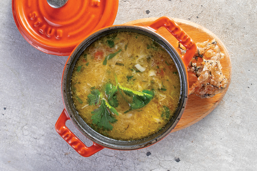 Panela Le Creuset laranja com escaldado de peixe