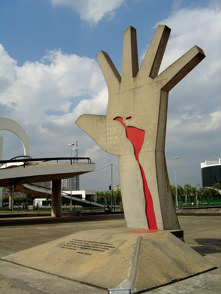 Memorial da América Latina A imagem mostra a escultura na Praça do Sol, uma mão aberta elevada com um desenho vermelho na palma dela.