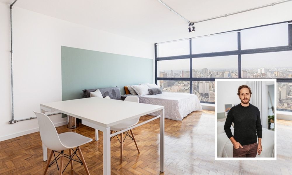 Rafael Steinbruch fundador da Yuca A imagem mostra um apartamento no Mirante do Vale, com uma sala e uma cama de casal ao fundo. Na montagem, há também uma foto de Steinbruch, com um a mão no bolso, olhando para a câmera