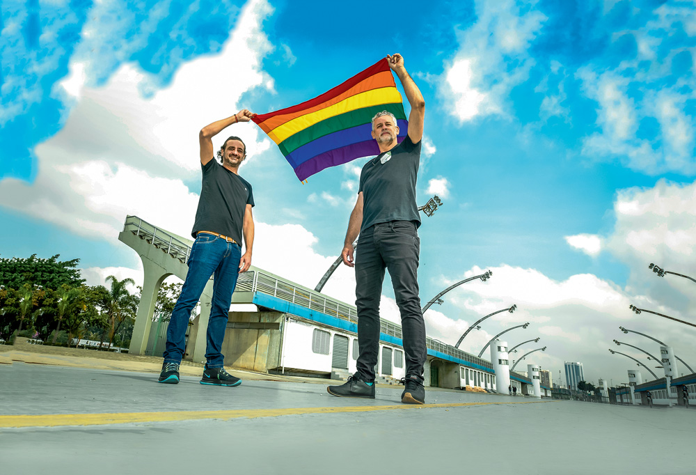 darlan e ricardo erguendo a bandeira lgbt ao vento no sambódromo do anhembi