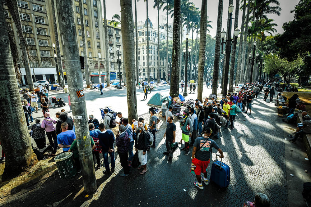 A imagem mostra uma longa fila formada na praça da Sé.