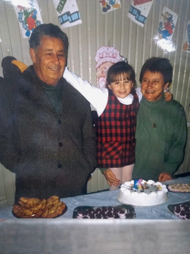Thais-Zimmer-Martins-história-avós-dia-dos-avós.jpg thais abraçada com os avôs José e Zilda, em sua festa de aniversário de 5 anos. à frente deles, uma mesa com bolo e docinhos
