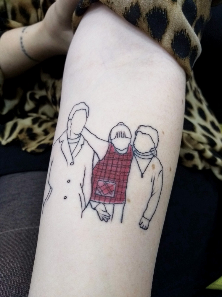 Thais-Zimmer-Martins-tatuagem-história-avós-dia-dos-avós.jpg foto do braço de thais que mostra a tatuagem que reproduz a cena dela sendo abraçada pelos avós