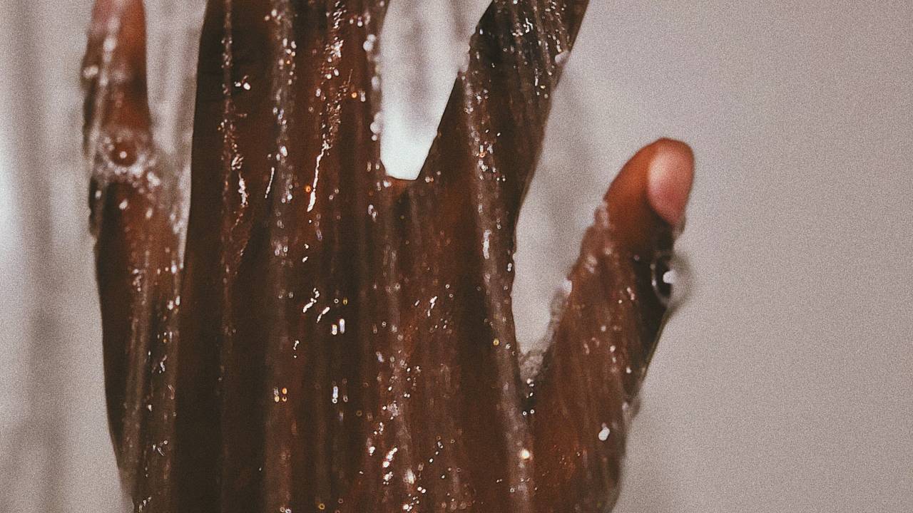 A imagem mostra uma mãe recebendo água de um chuveiro
