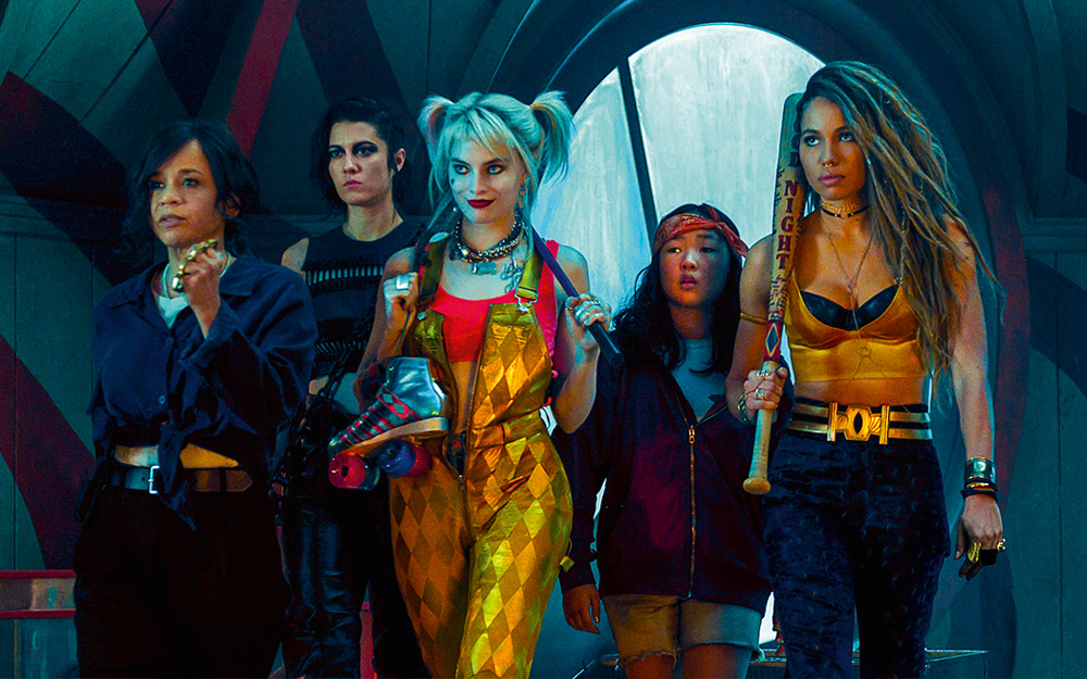 margotrobbie1.jpg A imagem mostra Robbie como Arlequina, andando com suas capangas em cena do filme Aves de Rapina