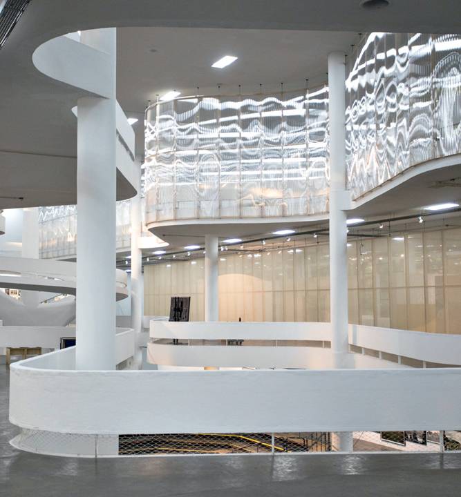 A imagem mostra artes interagindo com a estrutura da Bienal.