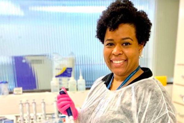 Imagem mostra Jaqueline sorrindo em laboratório de pesquisas