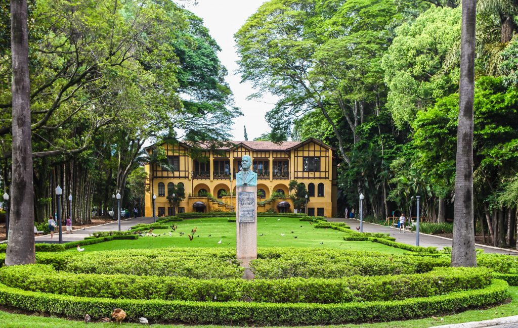 imagem de casarão preservado atrás de jardim no parque da água branca, em perdizes. também há um busto em homenagem a Fernando Costa