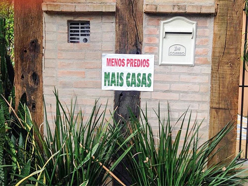 placa fixada em árvore de calçada em que lê-se 