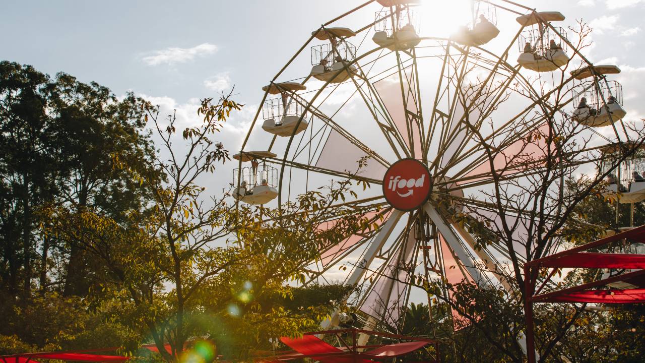 roda-gigante do ifood entre árvores em dia ensolarado