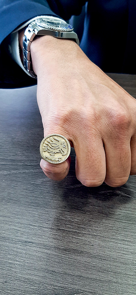 Anel do senador Alexandre Giordano Um anel de ouro com desenho de corvo está na mão de um homem, apoiada em uma mesa