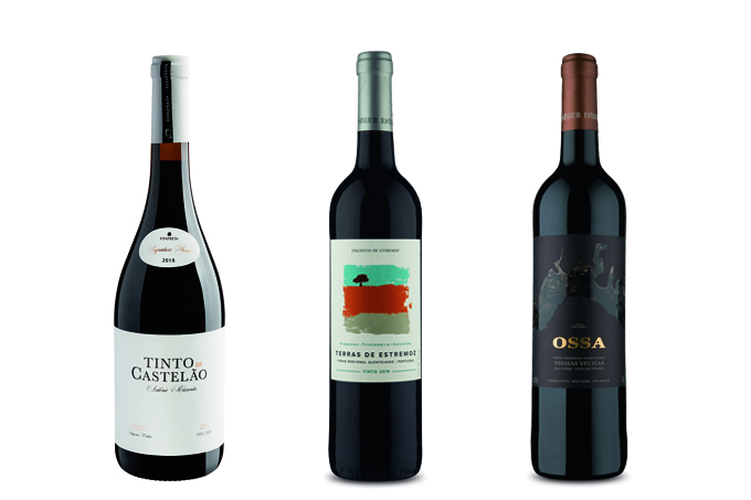 Três garrafas de vinhos tintos do Alentejo em fundo branco.