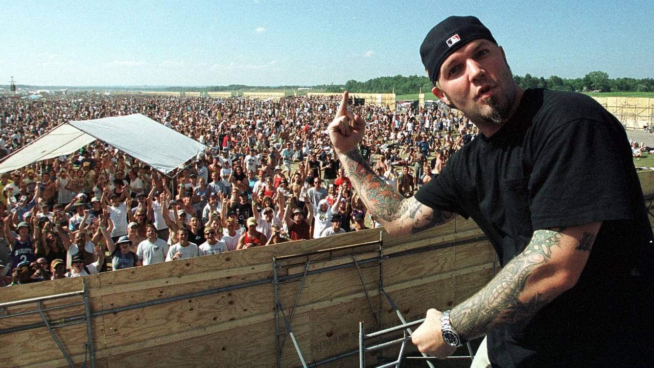 A imagem mostra o cantor Fred Durst em show durante o Woodstock