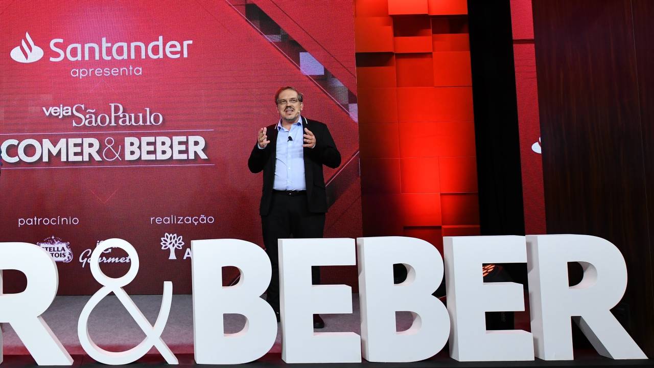 Arnaldo Lorençato sobre o palco da apresentação do guia COMER&BEBER.