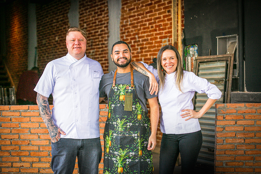 Alexandre Vorpagel, Michel Felício e Laura Oliveira em frente ao bar Bottega 21.