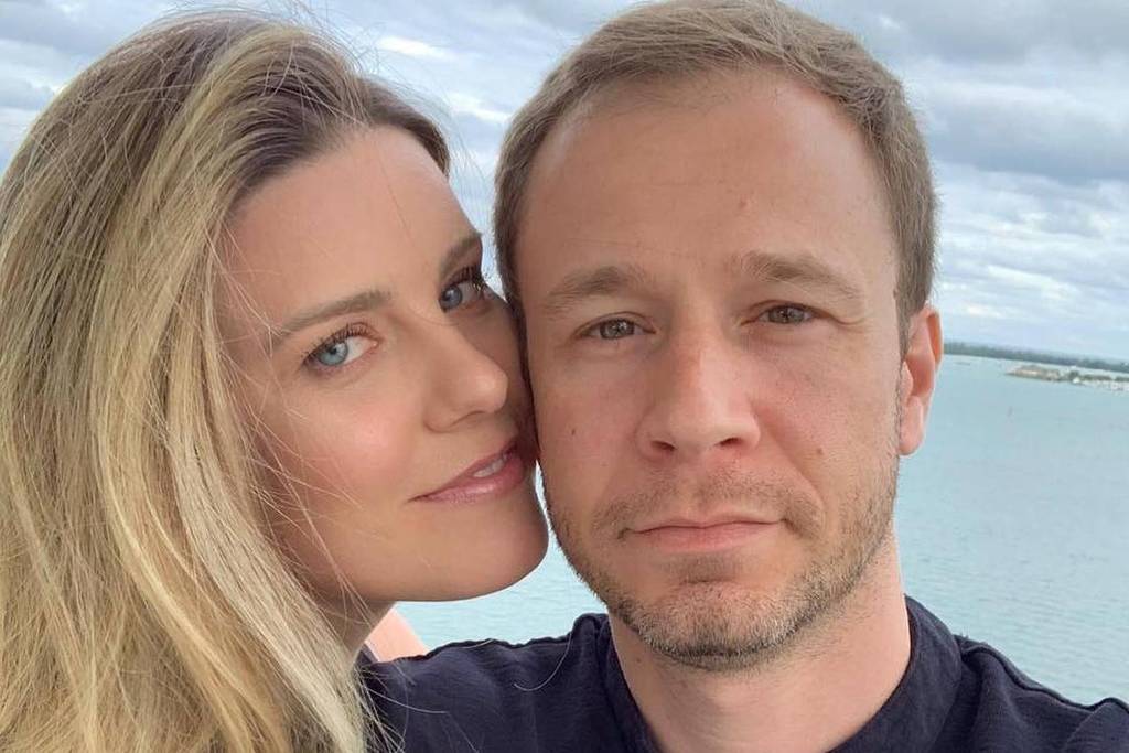 Daiana Garbin e Tiago Leifert posam juntos na praia.