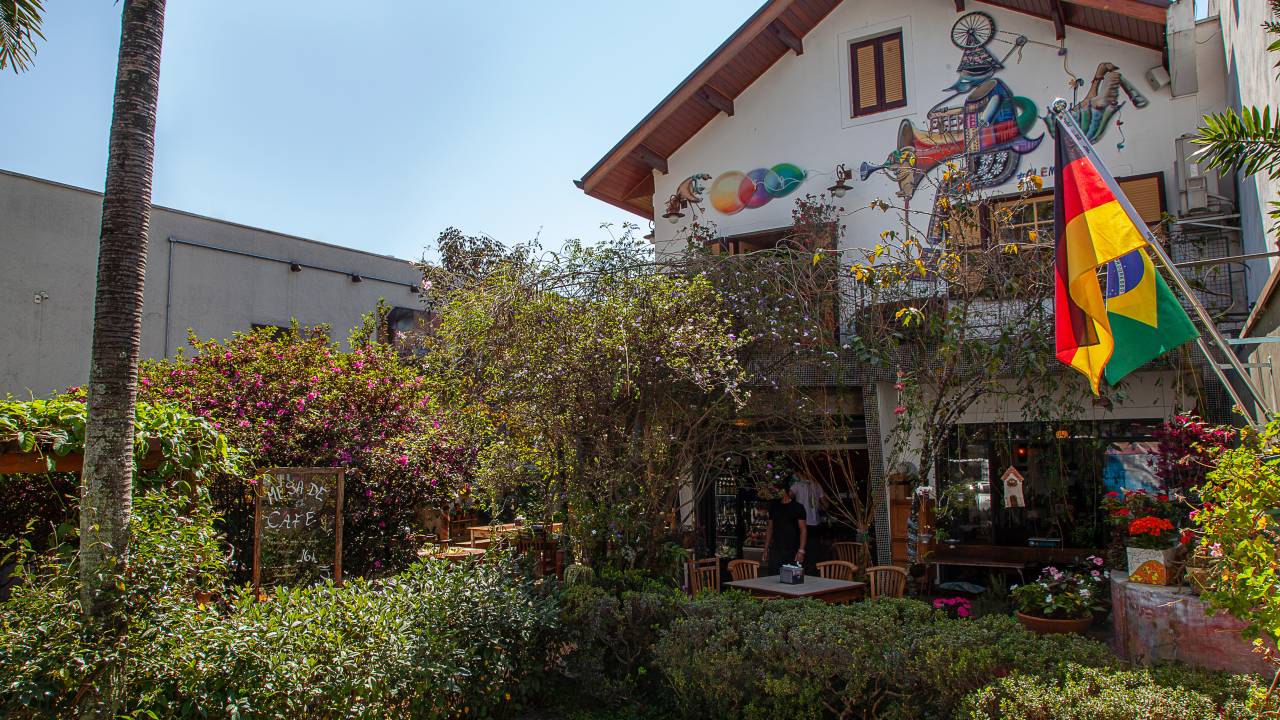 Fachada do restaurante Gansaral repleta de plantas na frente.