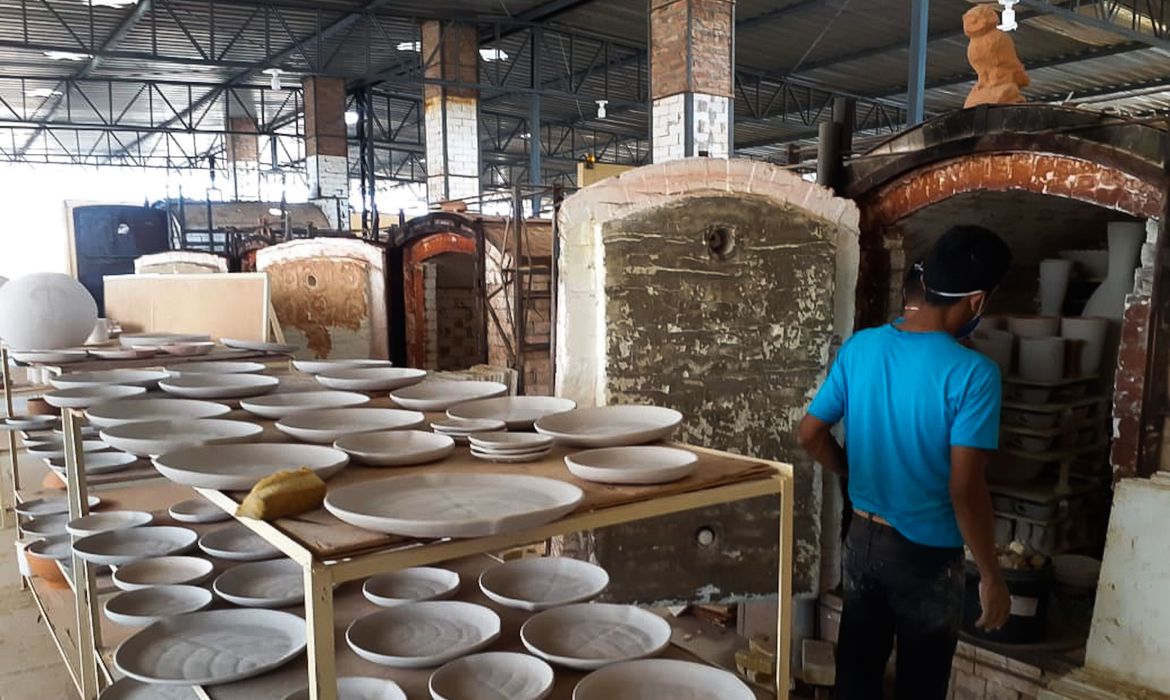 A imagem mostra artesãos que trabalham numa oficina
