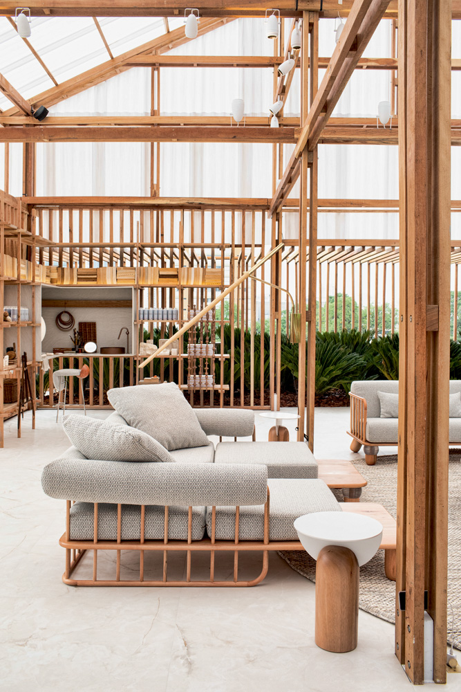 Romano ambiente casacor casa das caldeiras A imagem mostra uma sala com sofás e estruturada majoritariamente com madeiras, como em seus corrimões.